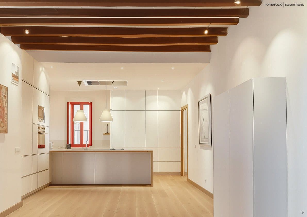 Cocina abierta con isla bajo las vigas de madera