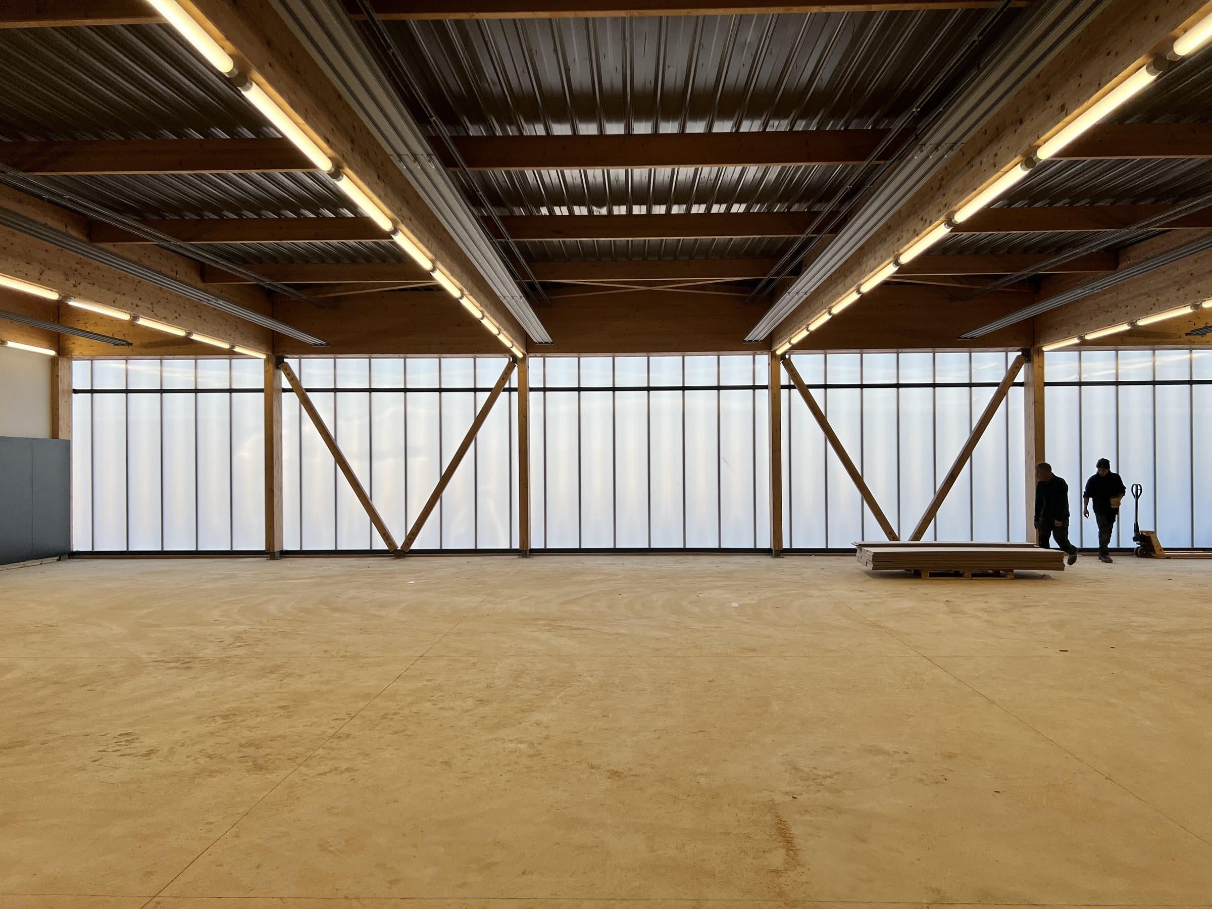 Interior de la sala: pórticos de madera y pared translúcida iluminada