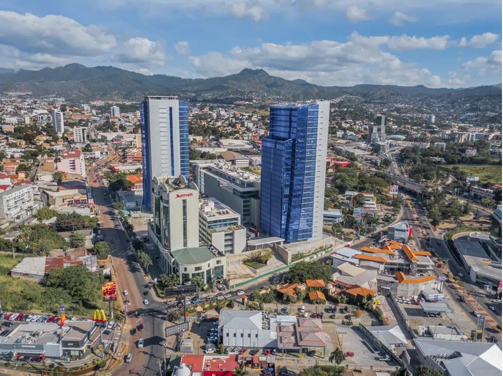 Panorámica aérea con la ciudad y las montañas al fondo