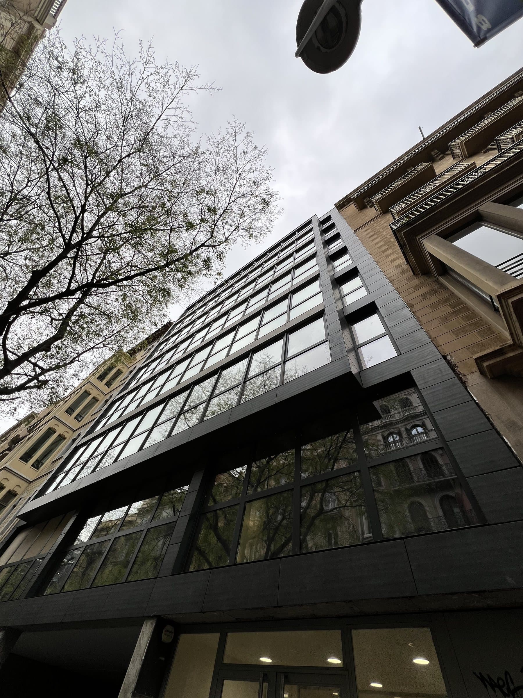 La fachada en contrapicado, con el edificio vecino al lado