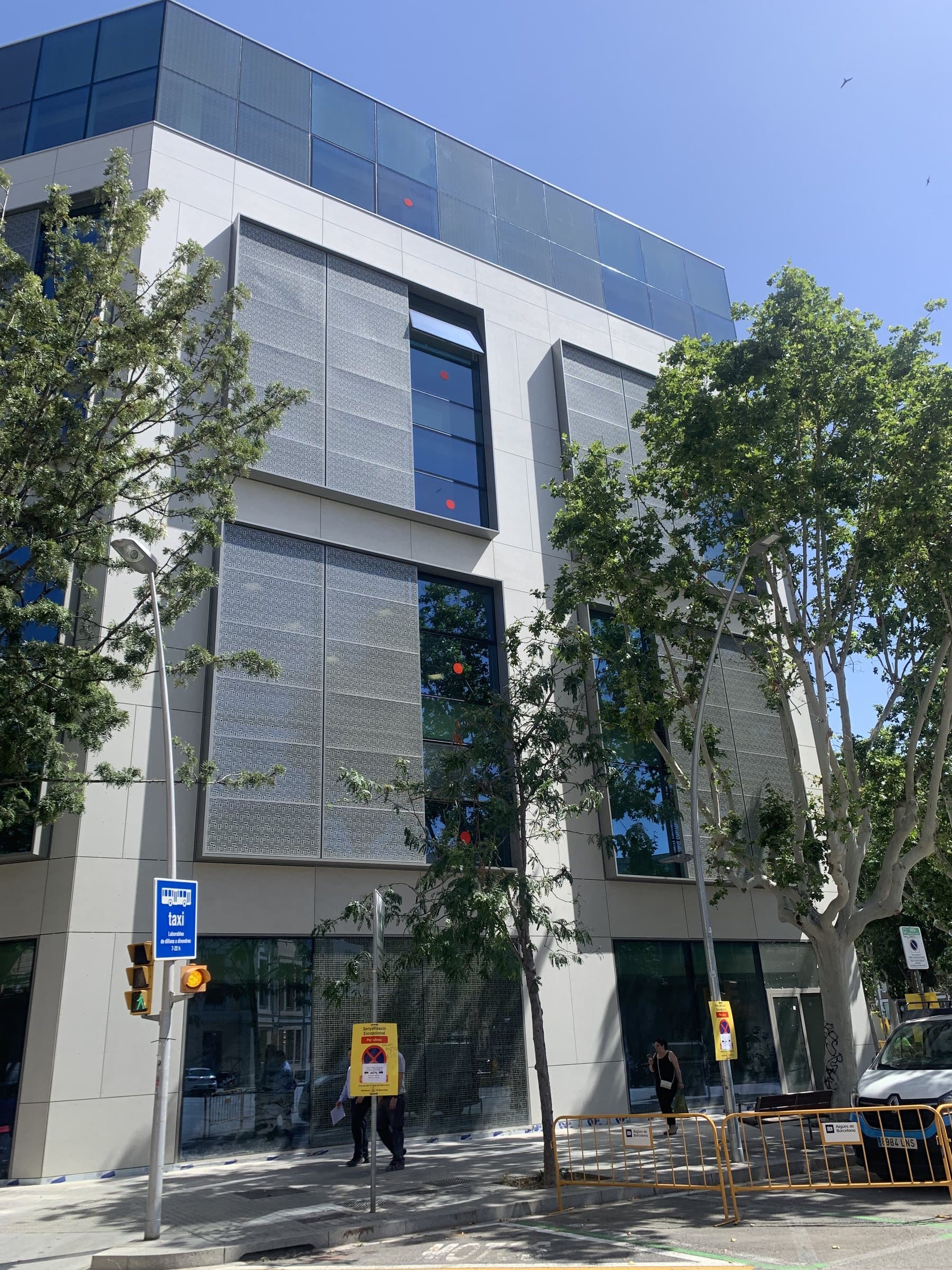 El edificio visto desde la acera con el arbolado de la calle